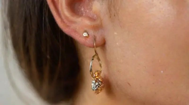 Detalle realista de oreja y joyas